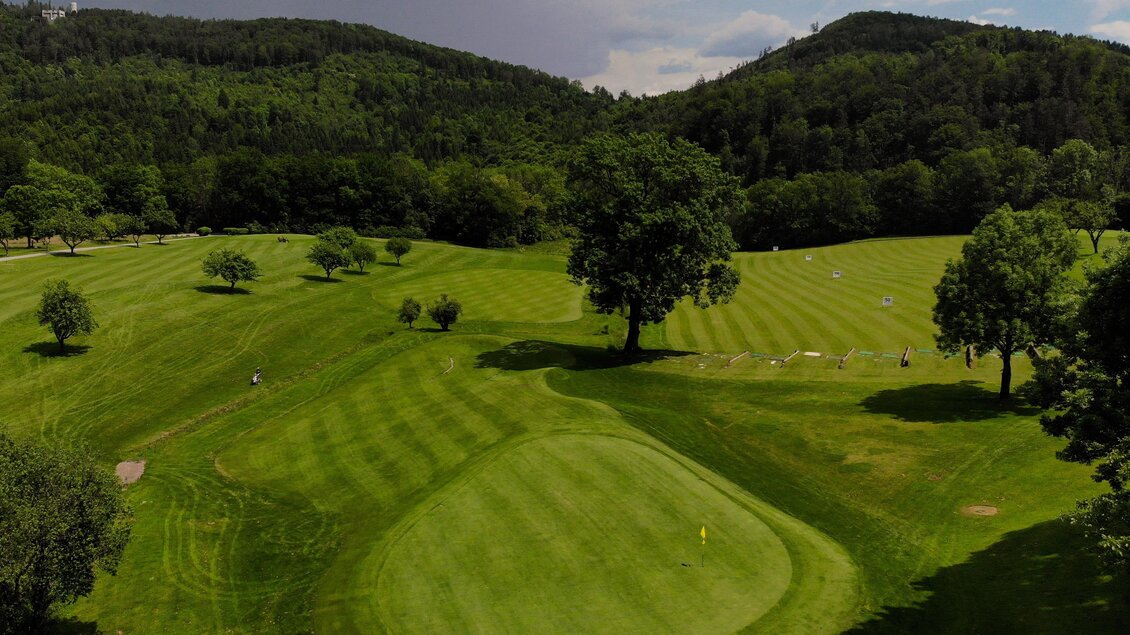 Ein weites, grünes Golfgelände mit gepflegten Fairways und Bäumen. Im Hintergrund sind sanfte Hügel und ein bewölkter Himmel zu sehen. | © GEPA Pictures