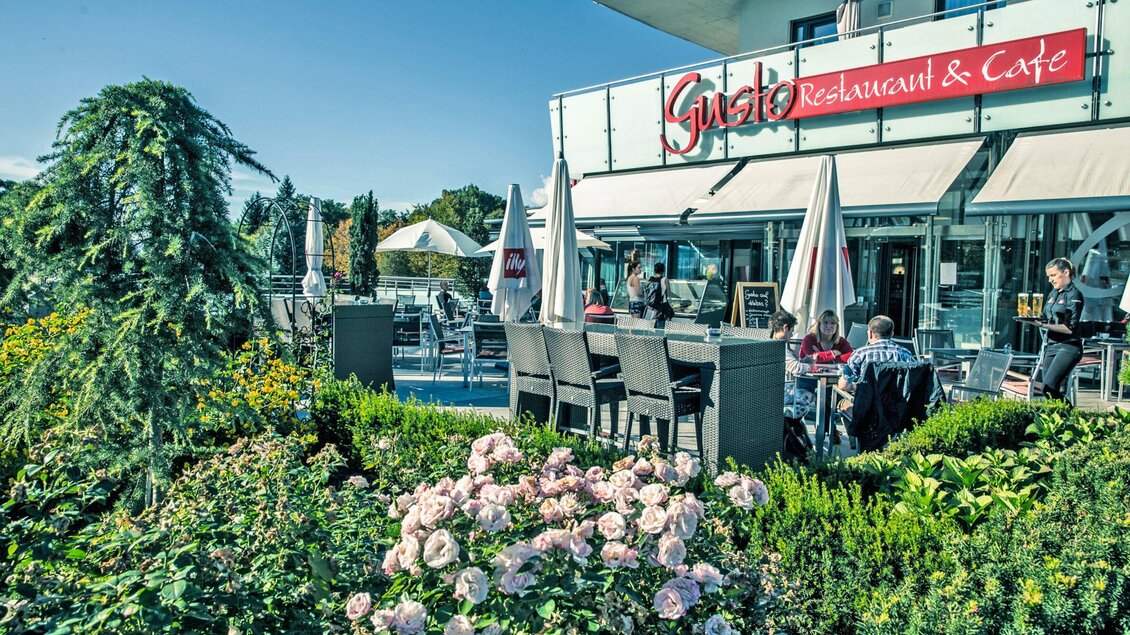 Ein gemütliches Restaurant mit einer einladenden Terrasse und vielen Gästen. Vor dem Restaurant blühen Rosengärten und es gibt sonnige Sitzecken. | © Gotthardt's Gusto