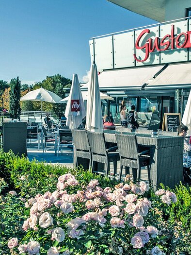 Ein gemütliches Restaurant mit einer einladenden Terrasse und vielen Gästen. Vor dem Restaurant blühen Rosengärten und es gibt sonnige Sitzecken. | © Gotthardt's Gusto