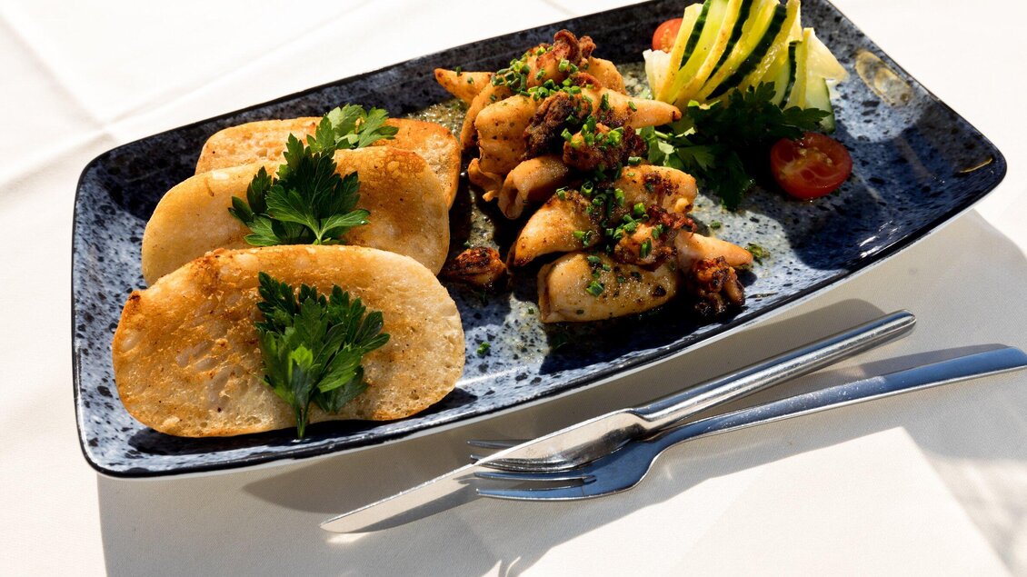 Ein Teller mit knusprigen Kartoffeltortillas und einer Mischung aus mariniertem Hähnchen und Gemüse. Garniert mit frischen Kräutern und Gemüsescheiben. | © TV Region Graz - Harry Schiffer