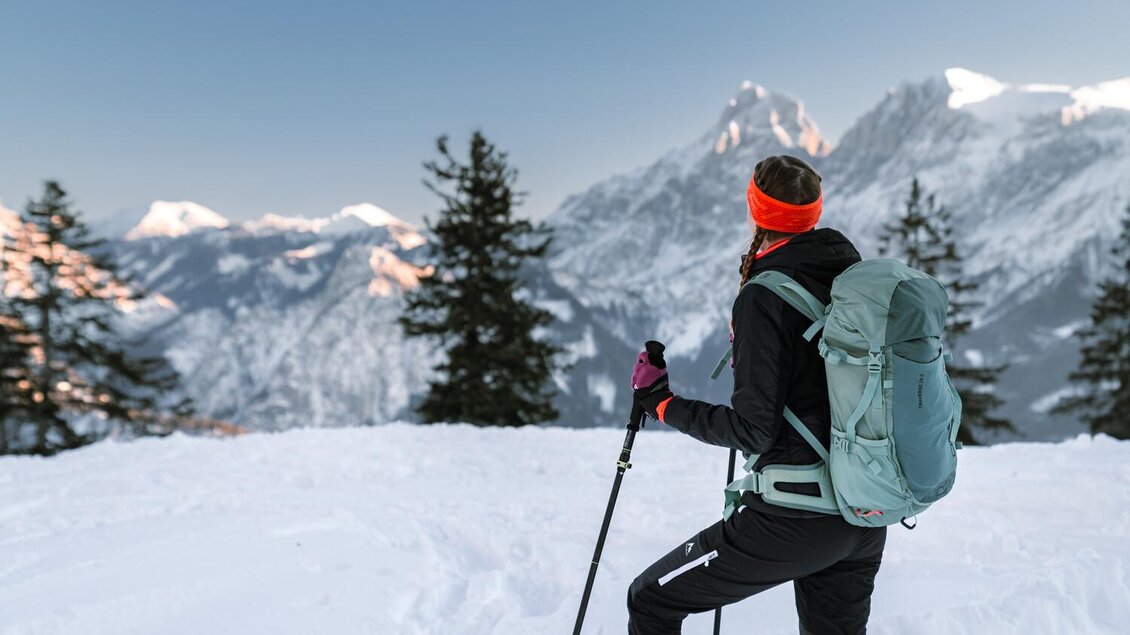 Ein Wanderer steht im Schnee und blickt auf die majestätischen Berge. Der Himmel ist klar und die Landschaft ist winterlich schön. | © Christoph Lukas