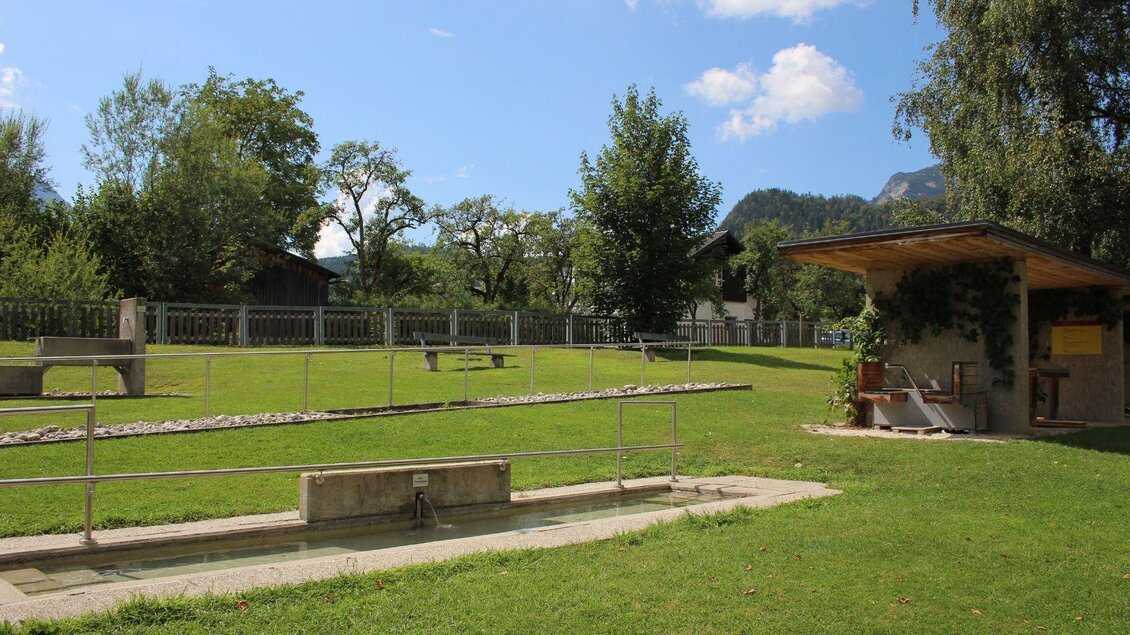 Ein gepflegter Garten mit grüner Wiese und schönen Bäumen. Im Hintergrund steht ein kleiner Pavillon. | © Viola Lechner
