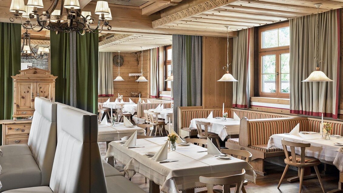 Ein gemütliches Restaurant mit Holzdekor und eleganten Tischen. Die große Fensterfront sorgt für eine helle und einladende Atmosphäre. | © GrafenWirt