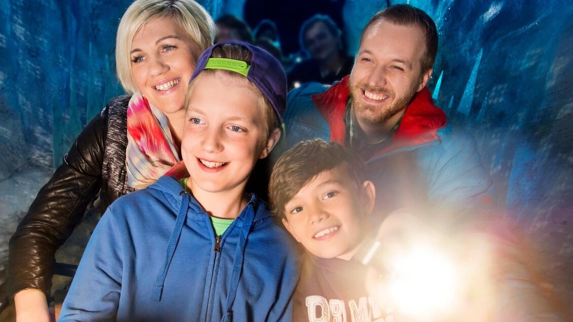 Familie fährt durch eisblaue Kulisse mit Eiszapfen in der Grazer Märchenbahn | © Grazer Märchenbahn-Hannes Loske