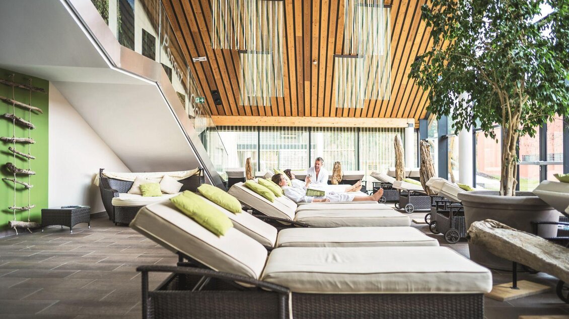 Ein moderner Wellnessbereich mit bequemen Liegen und großen Fenstern. Pflanzen sorgen für eine entspannte Atmosphäre. | © GrimmingTherme / P.Aldag