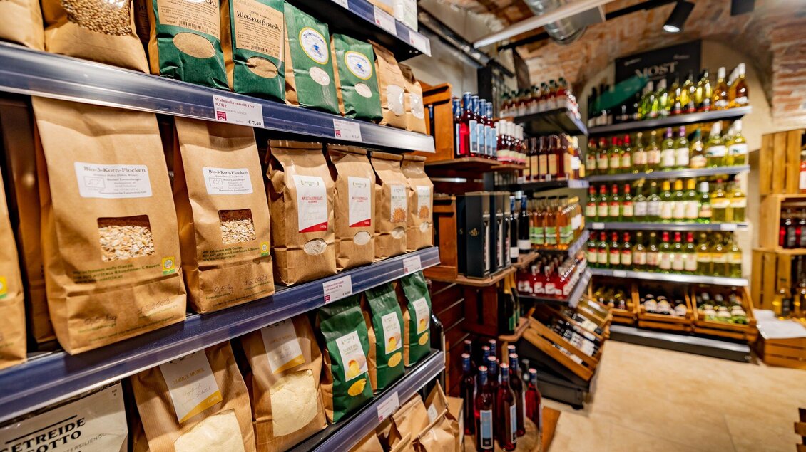 Ein einladender Laden mit Regalen voller Lebensmittelverpackungen und Flaschen. Die Atmosphäre ist warm und gemütlich. | © Gut Schlossberg