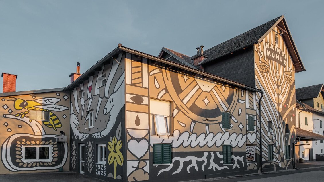 Bemalte Fassade der Haindl-Mühle in Kalsdorf bei Graz mit Mühlrad und Symbolen | © ee photograph - Elena Egger