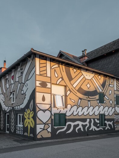 Bemalte Fassade der Haindl-Mühle in Kalsdorf bei Graz mit Mühlrad und Symbolen | © ee photograph - Elena Egger