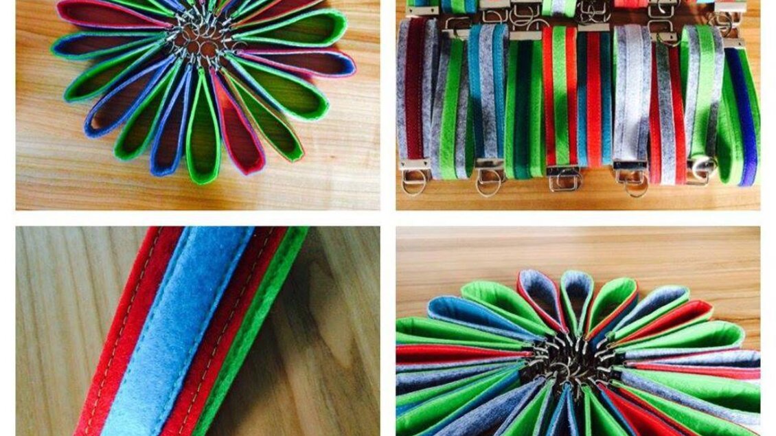 Bunte Stoffriemen in verschiedenen Farben und Designs sind auf einem Holzuntergrund angeordnet. Die Riemen sind in einem kreativen Muster angeordnet, das an eine Blume erinnert. | © Handarbeit Babsl Reiter