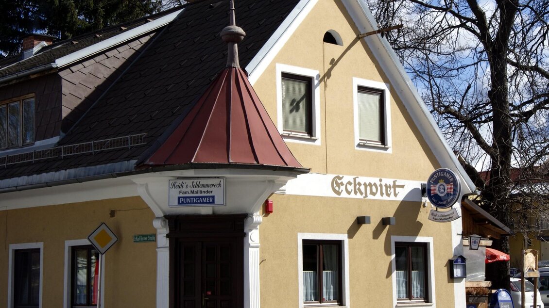 Ein gemütliches Gebäude mit einem roten Dach und gelber Fassade. An der Wand steht der Schriftzug „Eckwirt“ und es gibt ein paar Fenster in verschiedenen Größen. | © TV  Region Graz - Lunghammer