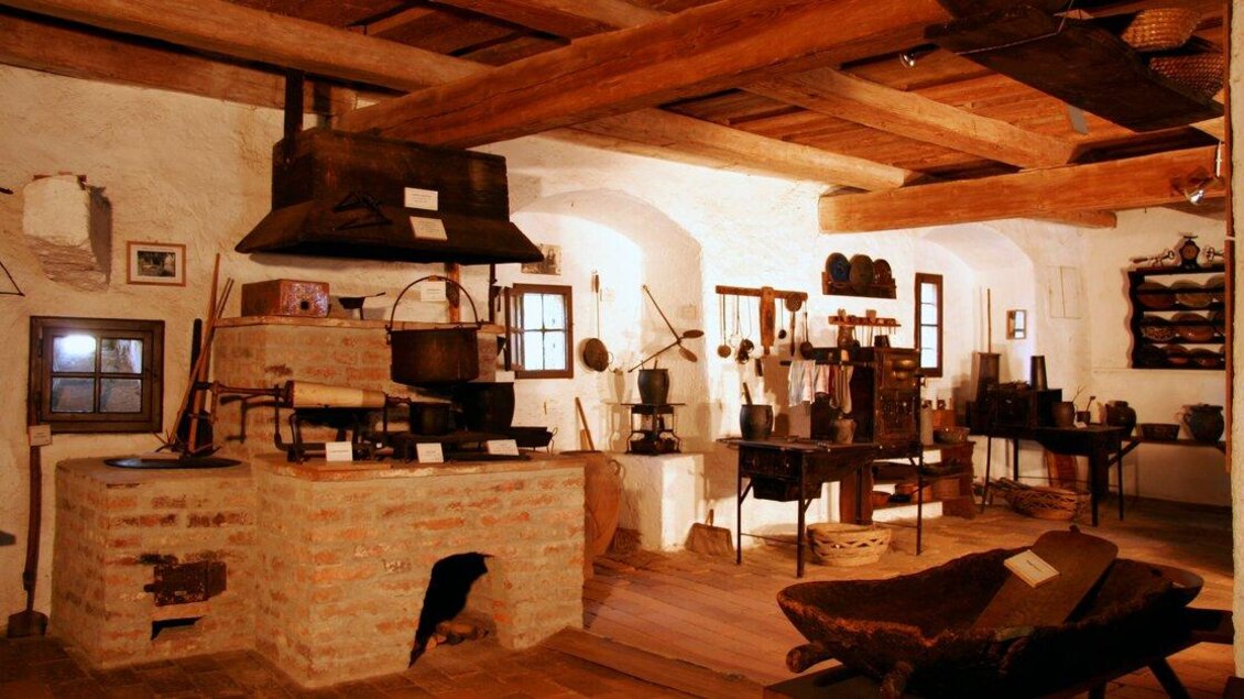 Eine traditionelle Küchenumgebung mit rustikalen Holzdecken und alten Kochutensilien. Die Atmosphäre vermittelt ein Gefühl von Geschichte und Handwerk. | © Heimat.Museum im Tabor