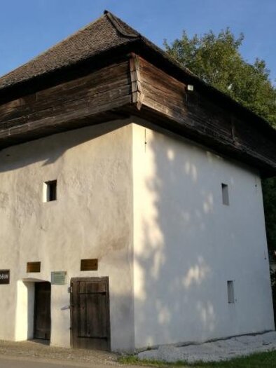 A simple, white building with a wooden roof. 
Surrounded by plants and trees in a rural setting. | © Marktgemeinde Mautern