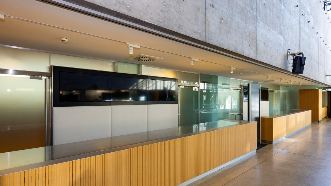 Leere Empfangstheke mit Holzverkleidung im Foyer der Helmut List Halle in Graz | © Graz Tourismus-Harry Schiffer