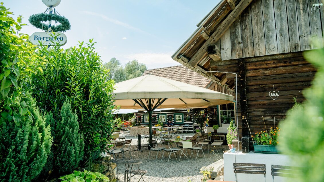 Ein einladendes Restaurant mit einem schönen Außenbereich und einem großen Sonnenschirm. Die Umgebung ist grün und freundlich gestaltet. | © Region Graz-Mias Photoart
