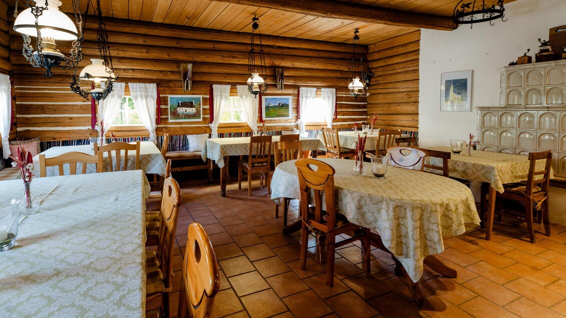 Ein gemütliches Restaurant mit Holzwänden und Tische, die mit weißen Tischdecken gedeckt sind. Sanfte Beleuchtung und rustikale Dekoration schaffen eine angenehme Atmosphäre. | © Region Graz - Mias Photoart