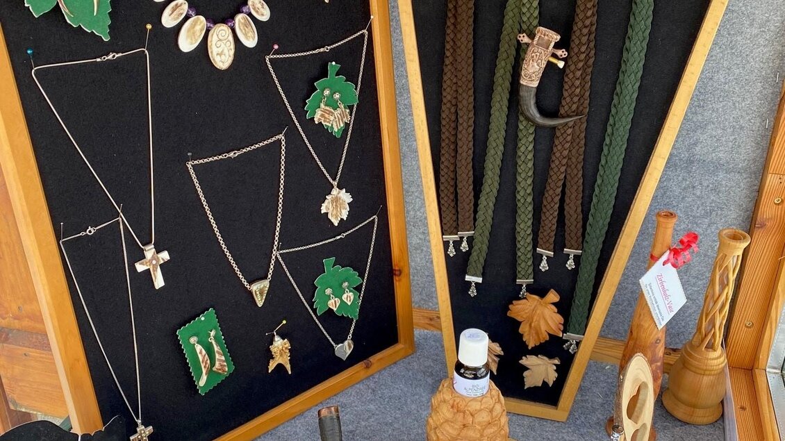 Eine Schmuckausstellung mit verschiedenen Halsketten, Broschen und Ohrringen. Die Schmuckstücke sind in ansprechender Präsentation auf schwarzen Tafeln angeordnet. | © Elisabeth Diethart