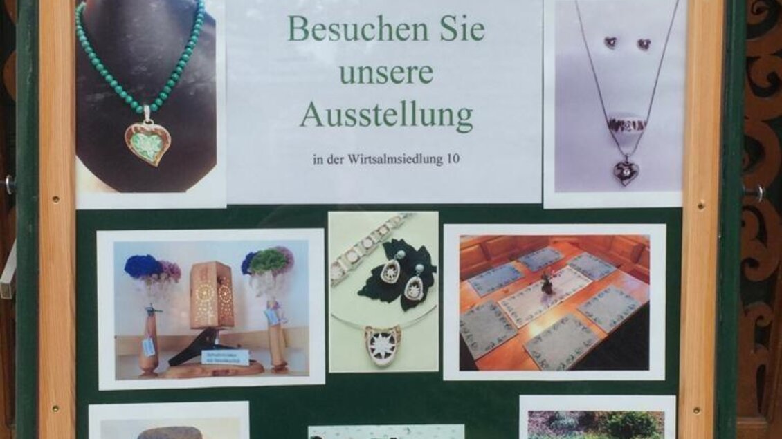 Ein Plakat zu einer Schmuckausstellung zeigt verschiedene Halsketten und  Accessoires. Es lädt die Besucher ein, die Ausstellung in der Wiesenfeldstraße 10 zu besuchen. | © Elisabeth Diethart