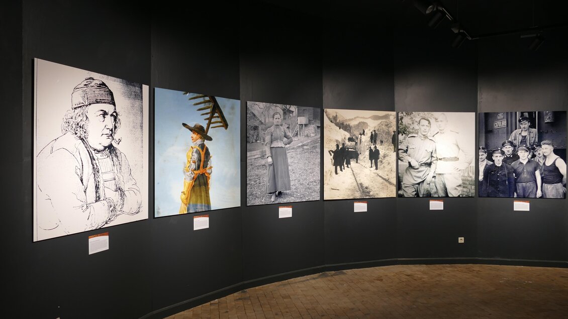 Eine Galerie mit mehreren Schwarz-Weiß- und farbigen Bildern. Die Fotos zeigen verschiedene historische Szenen und Portraits.