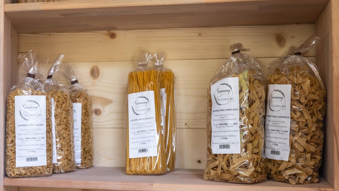 Eine Holzregal mit verschiedenen Sorten von Pasta in durchsichtigem Verpackungen. Die Etiketten sind gut sichtbar und beschriften die Nudeln. | © Martin Huber