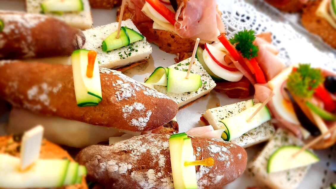 Eine Vielzahl von Häppchen auf einem Tisch. Die Snacks sind mit frischem Gemüse und Aufschnitt dekoriert. | © Sigrid Brukart