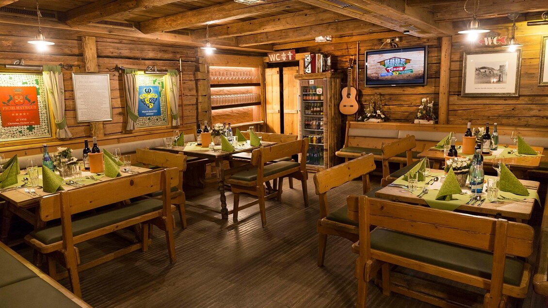 Ein gemütliches Restaurant mit Holzinterieur. Es sind Tische mit grünen Servietten und Getränken vorbereitet. | © AIR-Media.at