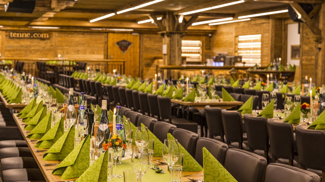 Ein festlich gedeckter Tisch mit grünen Servietten in einem großen Saal. Die Holzdecke und Wände sorgen für eine gemütliche Atmosphäre. | © AIR-Media.at