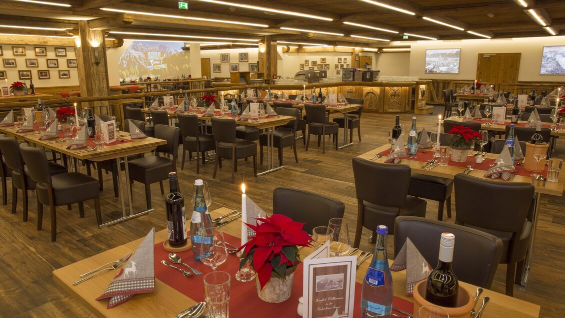 Ein geschmackvoll dekorierter Speisesaal mit mehreren Tischen. Die Tische sind mit roten Tischdecken und festlichen Blumenarrangements gedeckt. | © AIR-Media.at