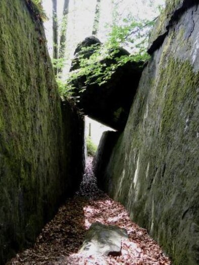 Ein schmaler Pfad zwischen hohen, moosbedeckten Felsen. Das Licht dringt durch die Bäume und schafft eine ruhige, natürliche Atmosphäre. | © Hohlkogel - Hohlfelsen