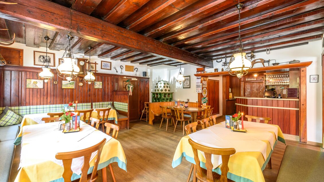 Ein einladendes Restaurant mit Holzbalkendecke und hellen Tischdecken. Die Tische sind dekoriert und der Raum wirkt gemütlich. | © Hotel Taferne