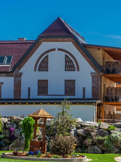 A modern house with two floors and balconies. The garden is well-kept and has beautiful plants as well as a small gazebo. | © Hotel Restaurant Perschler