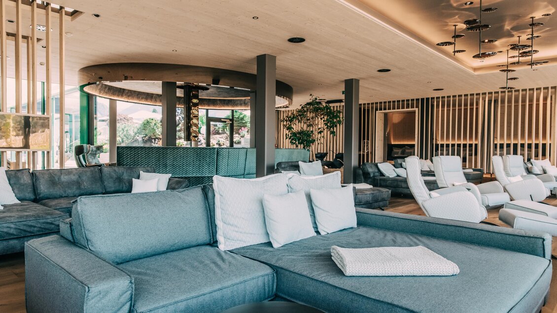 Ein eleganter Lounge-Bereich mit modernen Sofas und hellen Kissen. Große Fenster sorgen für viel Licht und eine gemütliche Atmosphäre. | © Hotel Schwaigerhof