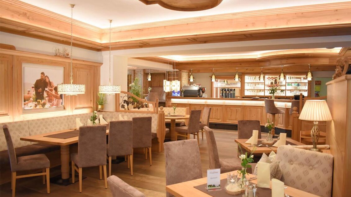 Ein gemütliches Restaurant mit Holzdekor und eleganten Tischen. Die Bar im Hintergrund bietet eine Auswahl an Getränken. | © Desiree Zwanzleitner
