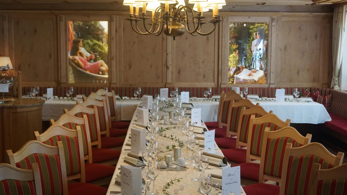 Ein stilvoll eingerichteter Speisesaal mit einem langen Tisch und roten Stühlen. Die Wände sind mit Holzverkleidungen und Bildern dekoriert. | © Kloepferkeller