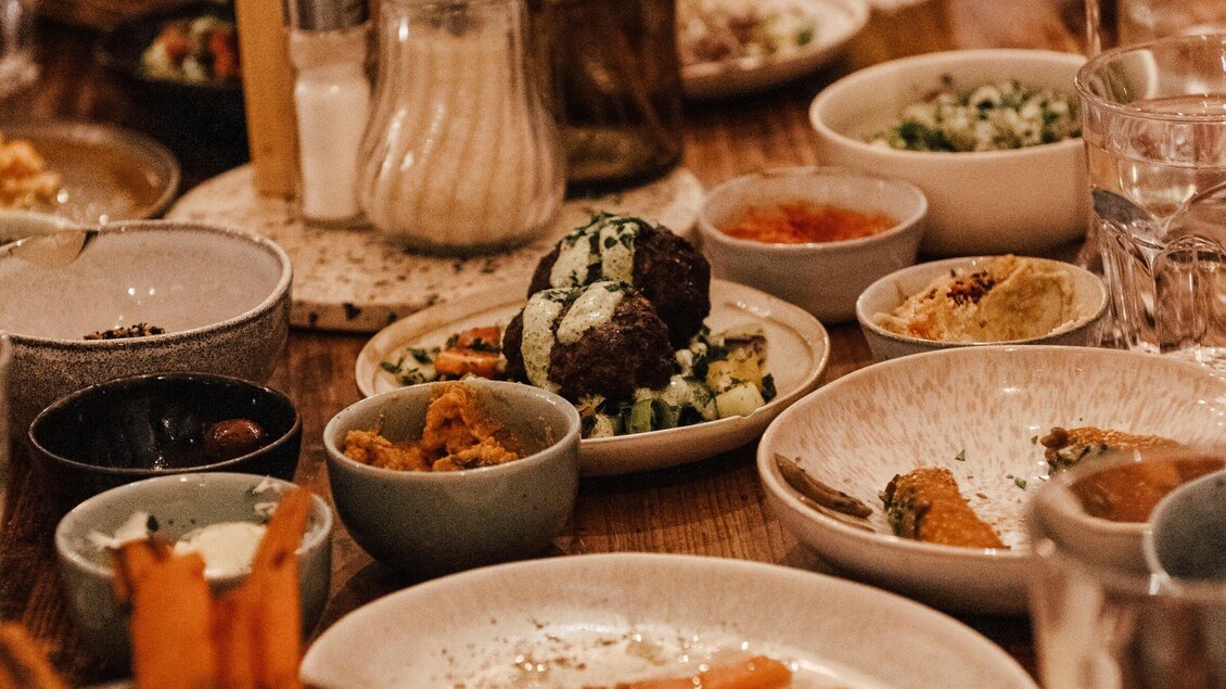 Ein Tisch voller köstlicher Speisen. Verschiedene Schalen mit Fleischbällchen, Salaten und Dips sind angerichtet. | © Hummel Graz