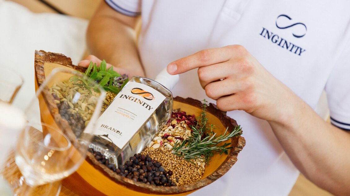 Eine Flasche Inginity Gin steht im Vordergrund. Im Hintergrund sind verschwommene warme Lichter zu sehen. | © © Thomas Brandl Spirits