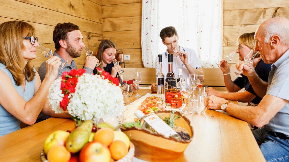 Ein junger Mann steht neben einer kupfernen Destillieranlage und hält eine Flasche in der Hand. Die Umgebung ist modern und gemütlich gestaltet. | © © Thomas Brandl Spirits