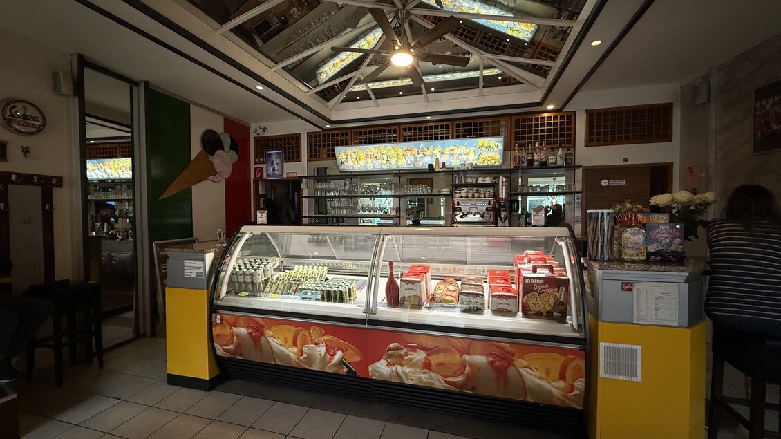 Ein gemütliches Eiscafé mit einem Präsentationsdisplay für Eiscreme. Die Inneneinrichtung ist freundlich und einladend. | © Taip Rastoder