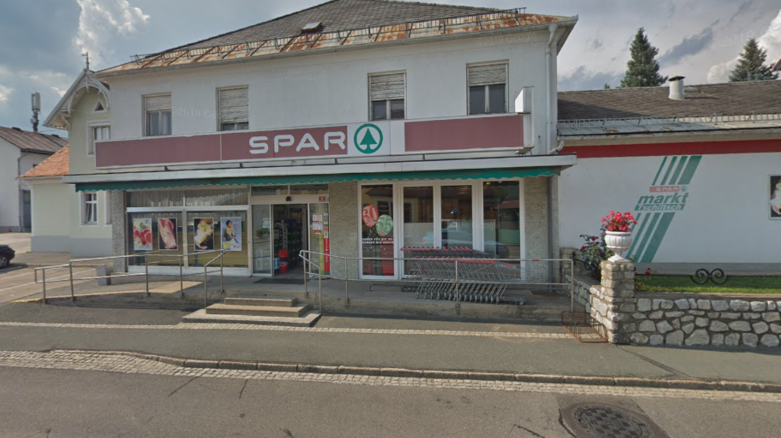 Ein Lebensmittelgeschäft mit dem Namen "SPAR" an der Vorderseite. Die Fassade ist einfach, mit einem Eingangsbereich und einigen Fenstern. | © Imbisstube Tschiltsch