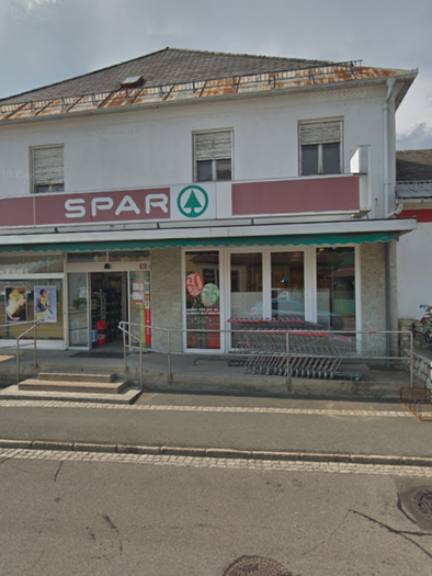 Ein Lebensmittelgeschäft mit dem Namen "SPAR" an der Vorderseite. Die Fassade ist einfach, mit einem Eingangsbereich und einigen Fenstern. | © Imbisstube Tschiltsch