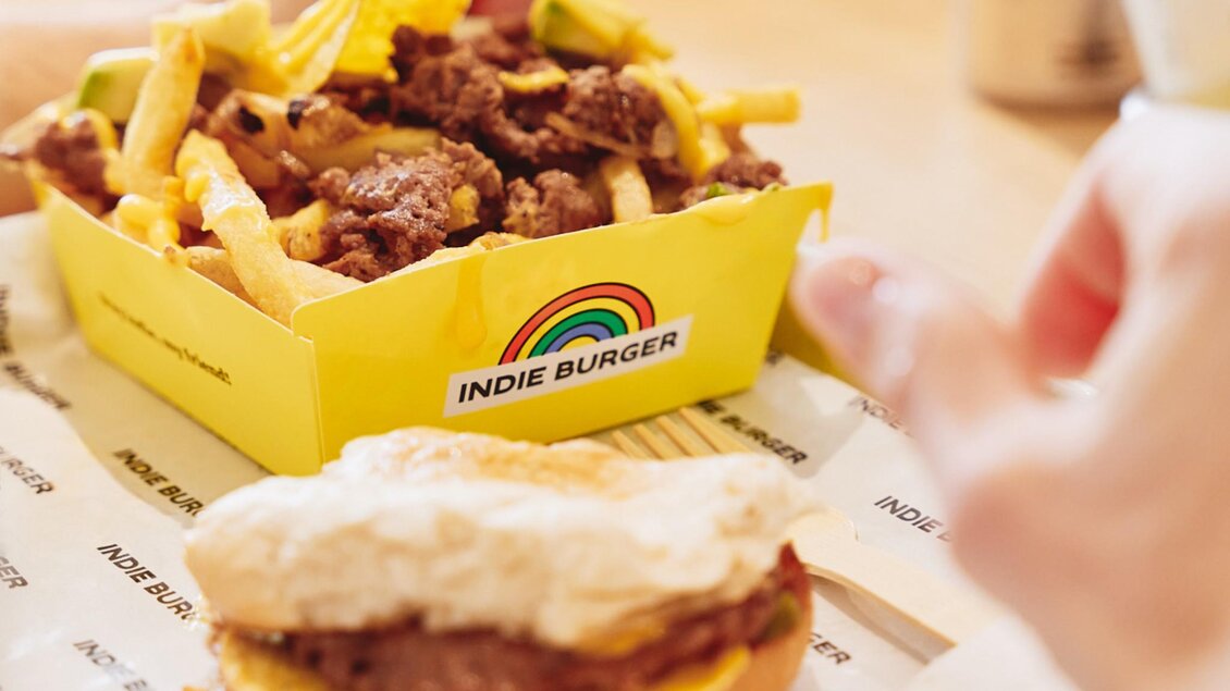  Nahaufnahme von Pommes mit Beef, Käse, Nachos und Burger auf Tablett. | © Indie Burger - Samuel Kuro