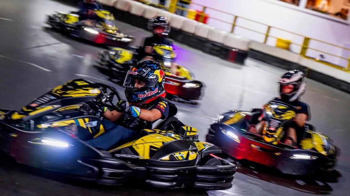 Eine Gruppe von Fahrern in Go-Karts fährt auf einer Rennstrecke. Die Karts sind schwarz und gelb, und die Fahrer tragen Helme. | © Indoorkart Spielberg