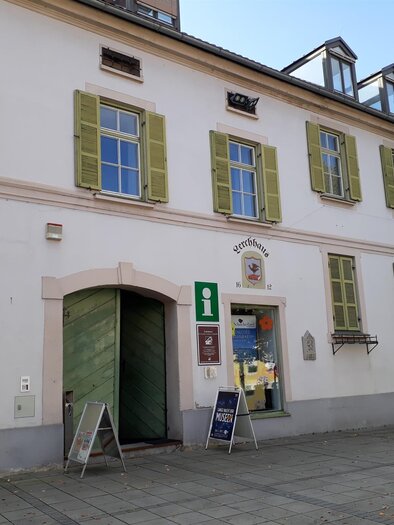 A historic building with green shutters. The entrance is clearly visible, and there are signs indicating information. | © Schilcherland Steiermark
