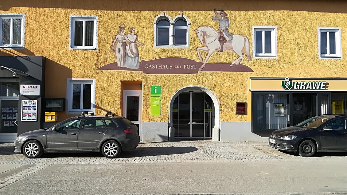 Ein gelbes Gebäude mit einem eindrucksvollen Wandgemälde, das einen Ritter auf einem Pferd zeigt. Vor dem Gebäude stehen zwei Autos geparkt. | © TVB Gröbminger Land