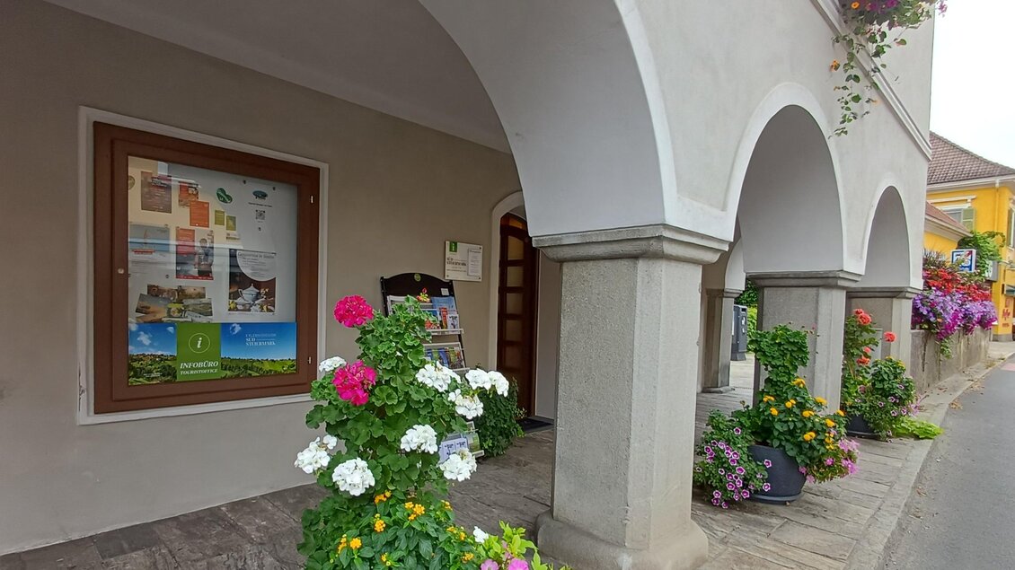 Ein einladender Eingangsbereich mit Bögen und bunten Blumen. An der Wand ist ein Informationsschild zu sehen. | © TVB Südsteiermark - Irene Löschnig