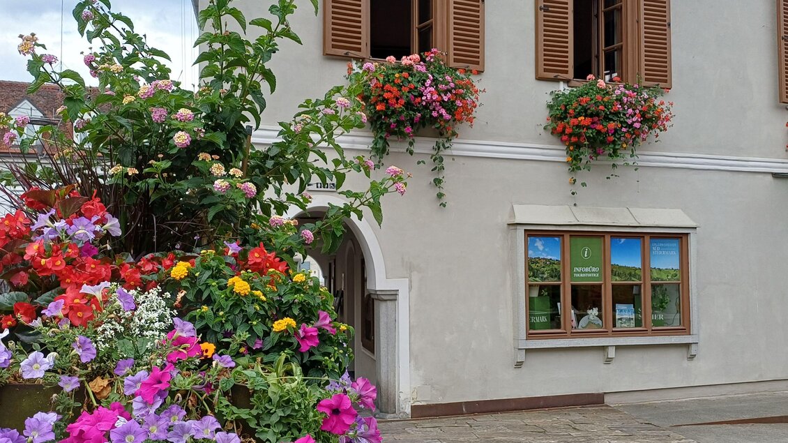 Ein charmantes Gebäude mit blühenden Blumen vor den Fenstern. Die bunten Pflanzen verleihen der Fassade Leben und Farbe. | © TVB Südsteiermark - Irene Löschnig