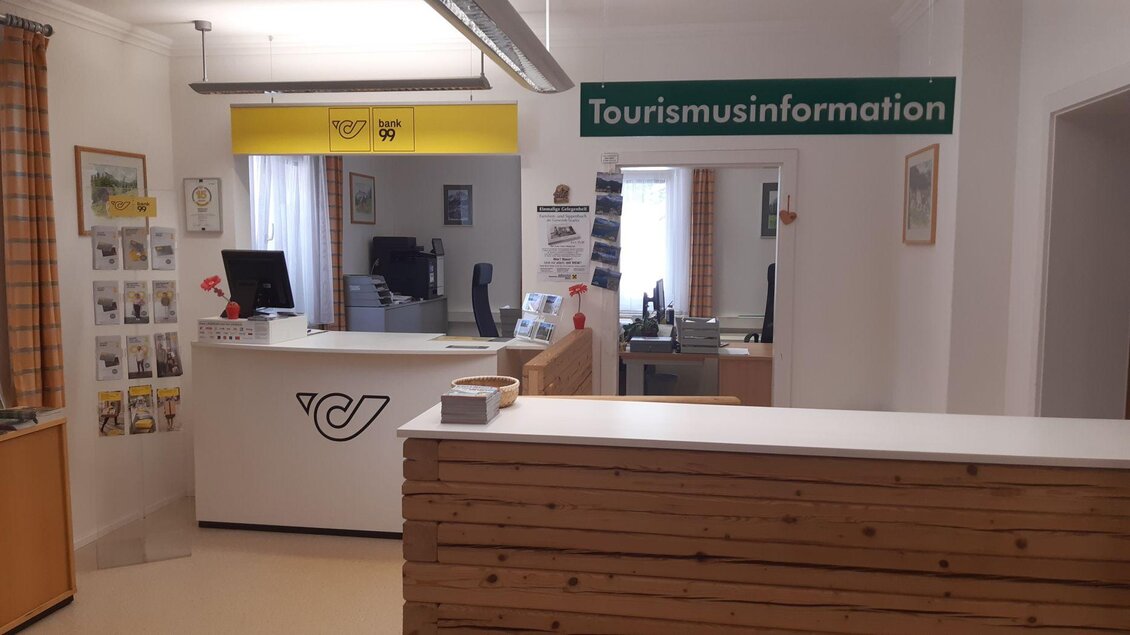 Ein Empfangsbereich der Touristeninformation mit einem modernen Schalter. An der Wand hängt ein Schild mit der Aufschrift "Tourismusinformation". | © TVB Ausseerland Salzkammergut/Raunigg