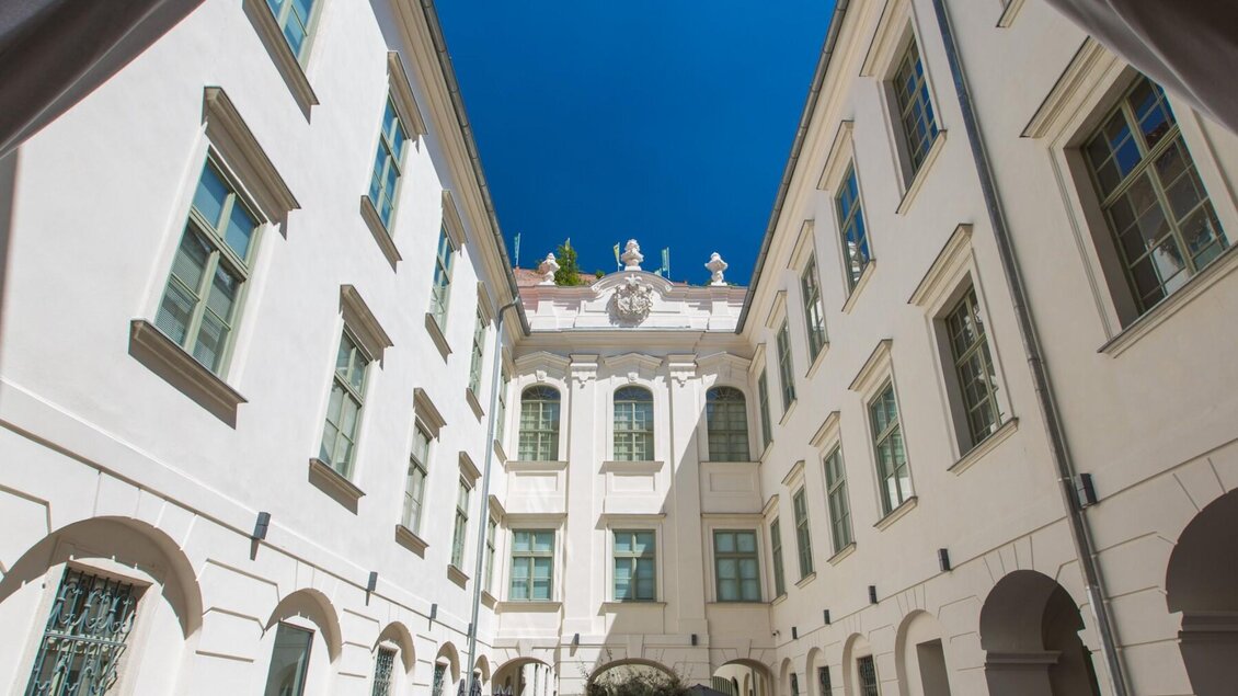 Heller Innenhof des Palais Herberstein in Graz mit Arkaden und Cafébereich | © Graz Tourismus-Harry Schiffer