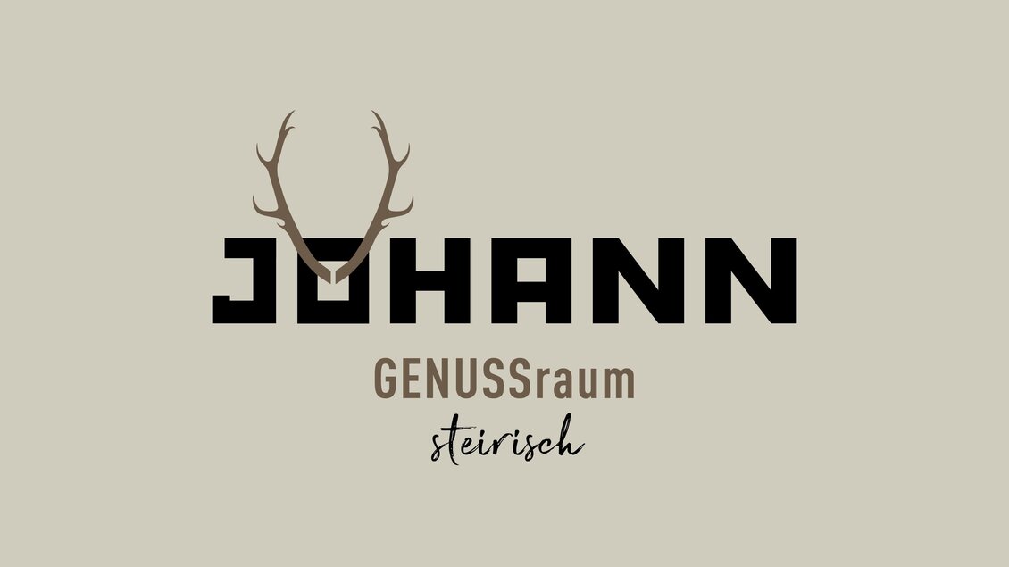 Ein stilvolles Logo mit dem Namen "JOHANN" und dem Zusatz "GENUSSraum steirisch". Es zeigt ein modernes Design mit Geweih-Elementen auf einem neutralen Hintergrund. | © JOHANN Schladming