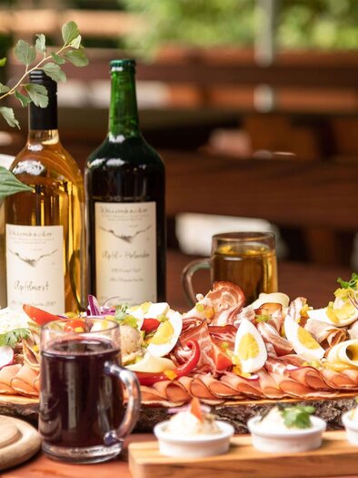 A rich buffet with various seafood, eggs, and fresh ingredients. In the background, there are bottles of wine and a plant element. | © Jufa Hotels