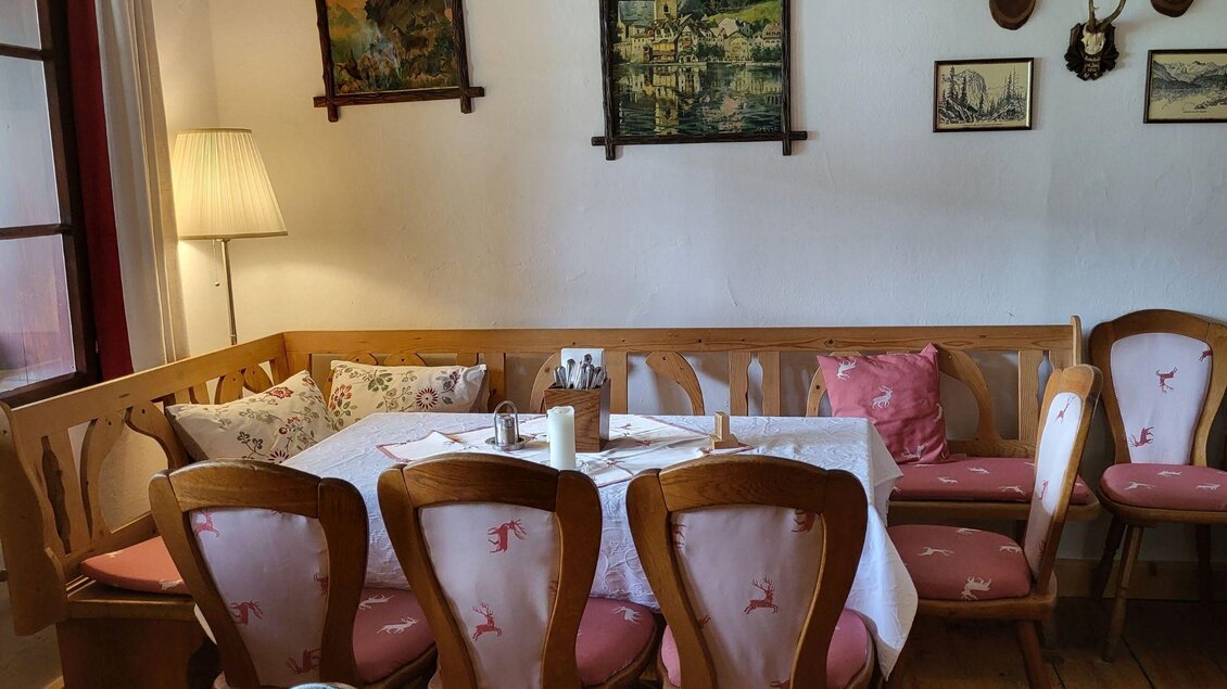 Ein gemütlicher Essbereich mit Holzdekor und bequemen Stühlen. An den Wänden hängen Bilder und Jagdtrophäen. | © Petra Kirchschlager